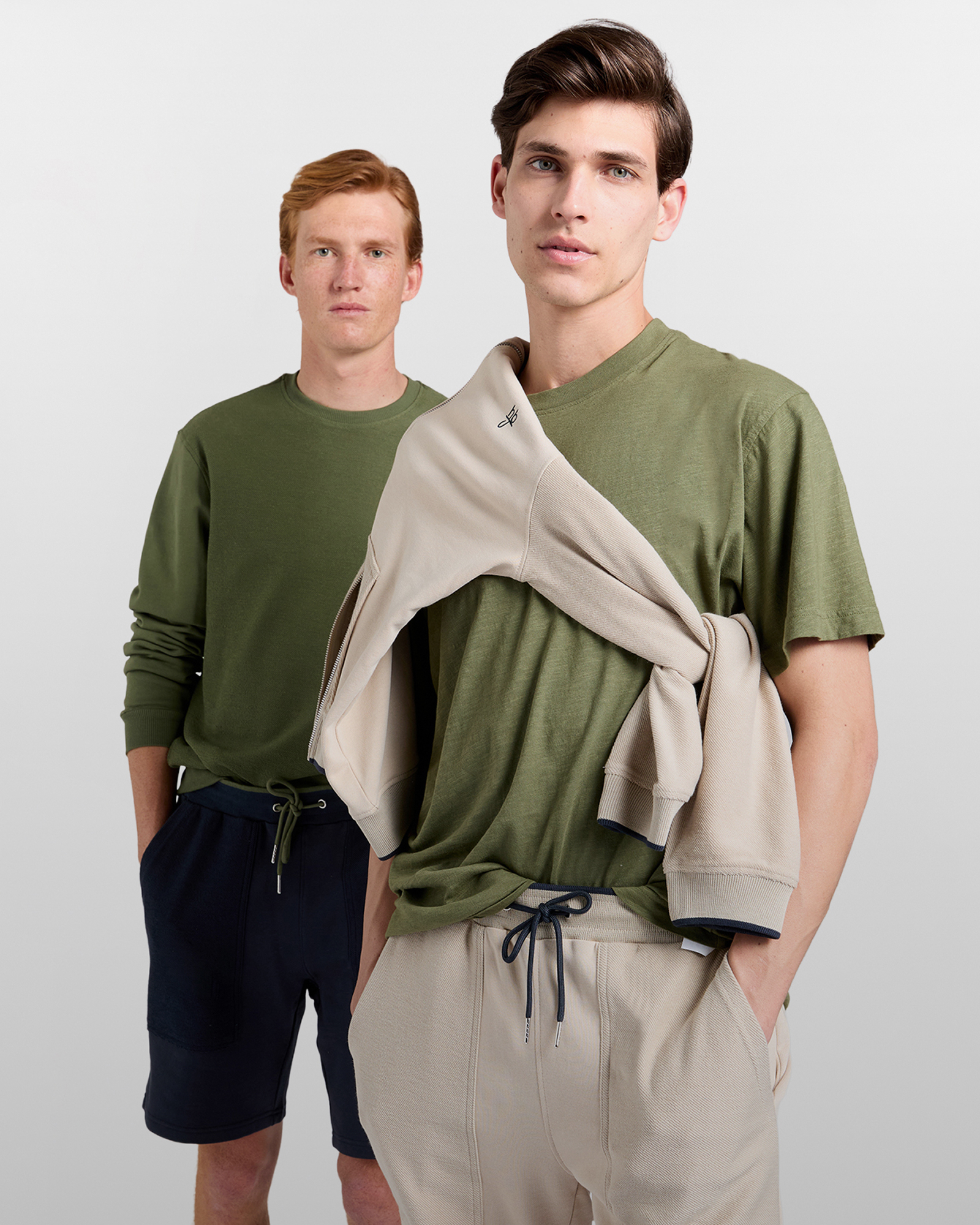 Coppia in spiaggia con polo a righe e cappellini da baseball